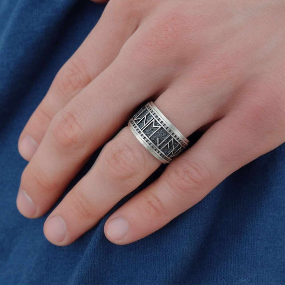 A custom rune stone wedding band displayed on a hand, narrating a saga of timeless devotion.